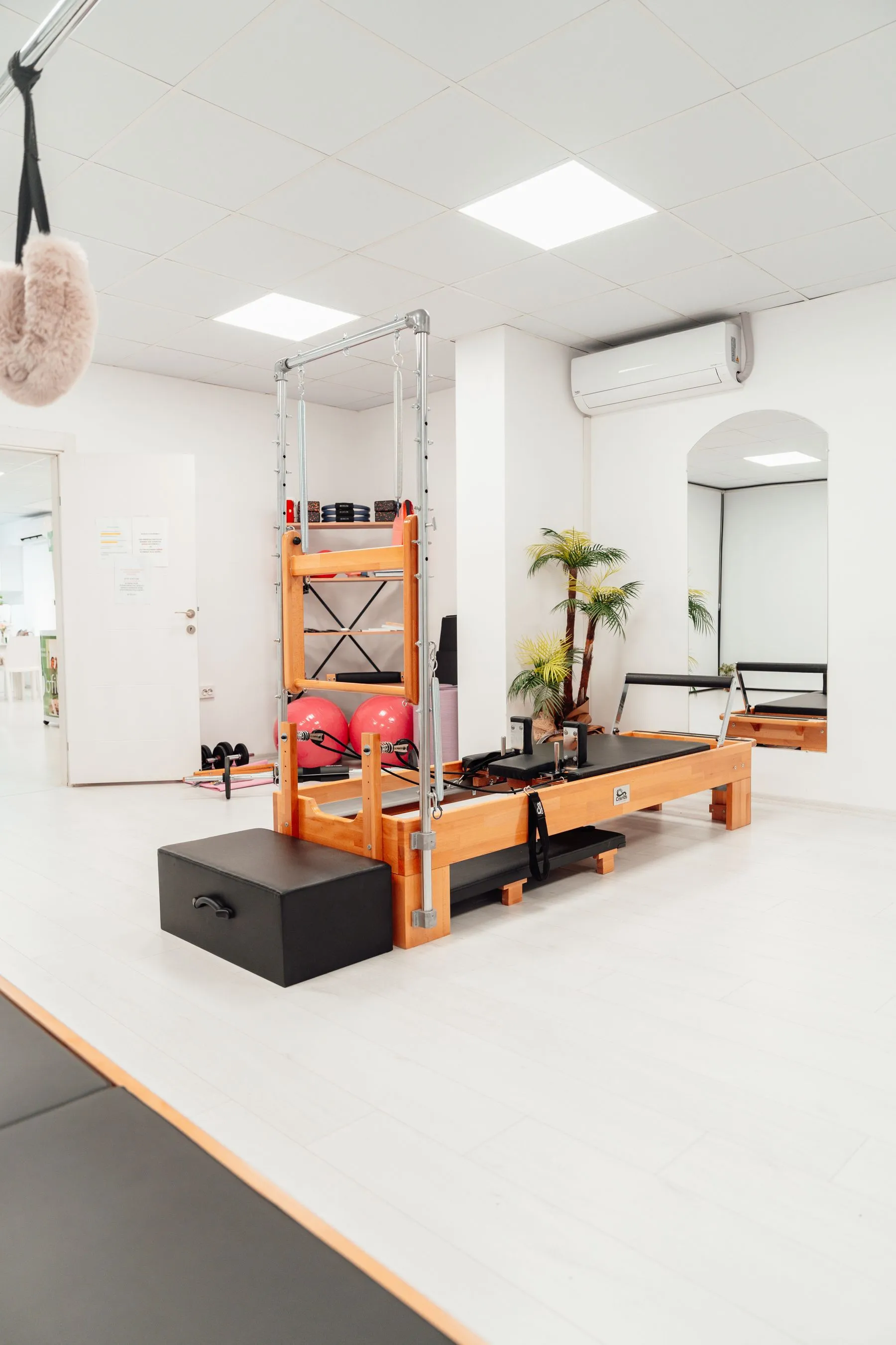 Sala de pilates clara com aparelhos reformer e cadillac